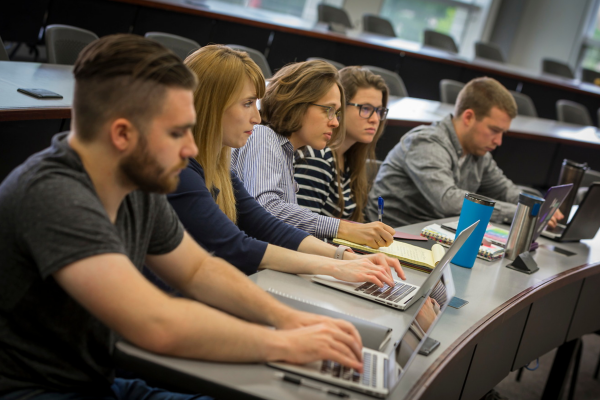 Row of students with their laptops in class.