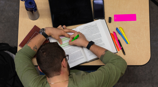 student reading through a textbook