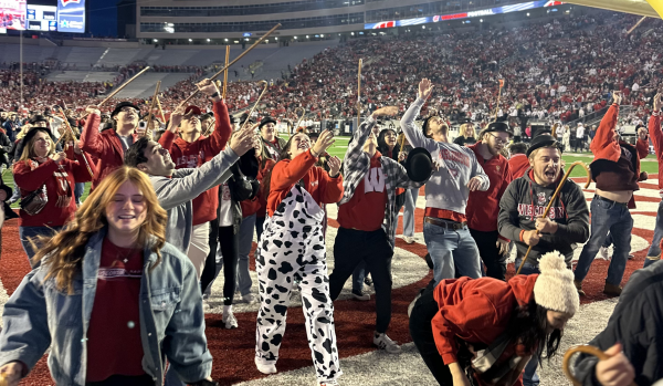 students running on the field of Camp Randall for cane toss 2021