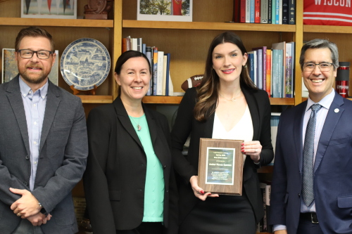 A group photo showing the 2023 Best Brief winner, Amber Renee Quinlan, standing with professors and the Law School Dean in front of a bookshelf.