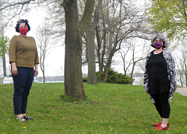 Sarah Davis and Jill Jacklitz standing apart by a lake and wearing masks