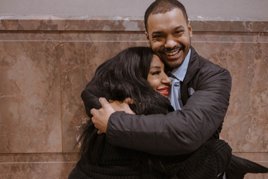 An woman hugs a man.