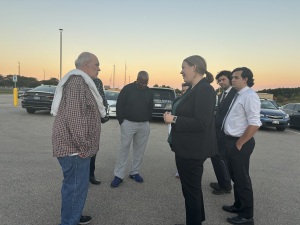 David Bintz stands with people in a parking lot.