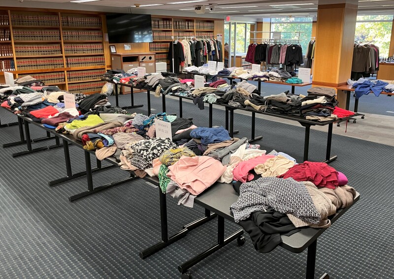 A room with tables covered in clothing items.