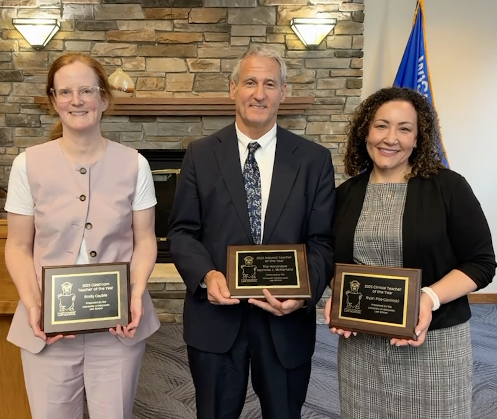 three people standing with awards