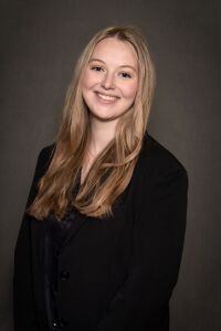 Woman with blonde hair and black blazer