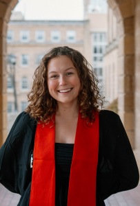 Rosie in a black graduation gown with red stol