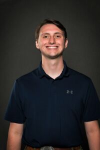 Man with short brown hair, navy shirt