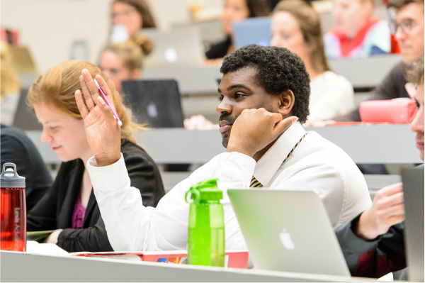 Student raising their hand in class.